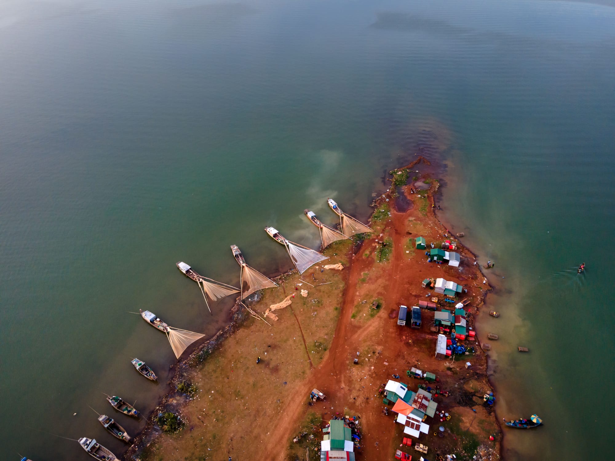 Aerial view of Vietnamese fishing boats and nets moored along a coastal harbor — the kind of scene visible from Dinh Cau's terrace in Phú Quốc